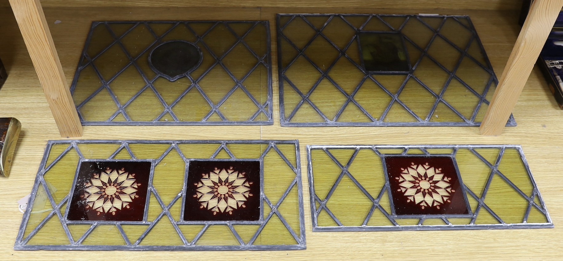 Four late 19th century leaded and stained glass panels, various sizes, with central cartouche 53cms wide x 41cms high